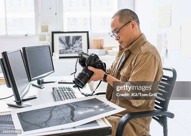 korean photographer using camera at desk - asian photographer stock pictures, royalty-free photos & images