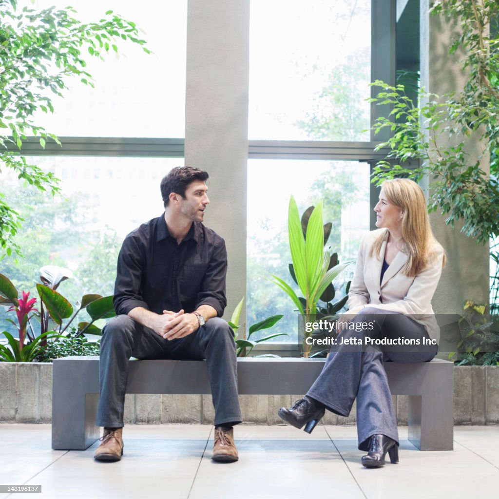 Caucasian business people talking in office lobby