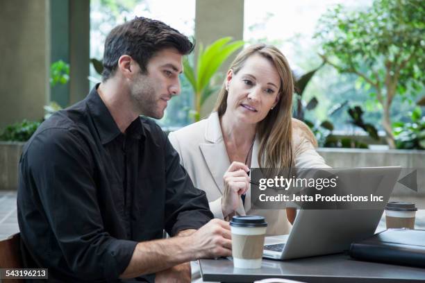 caucasian business people using laptop at table - food court stock pictures, royalty-free photos & images