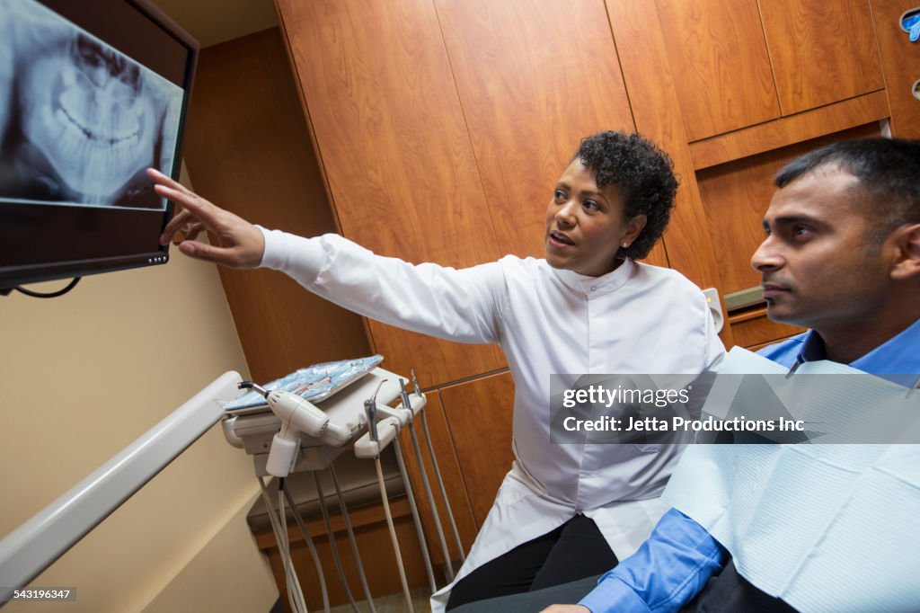 Dentist showing x-ray to patient in office