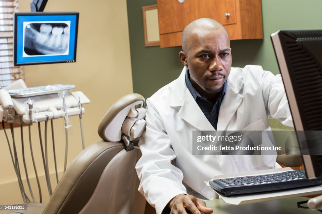 Black dentist using computer in office