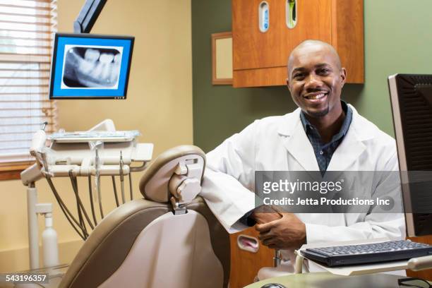 black dentist smiling in office - dental office front stock pictures, royalty-free photos & images