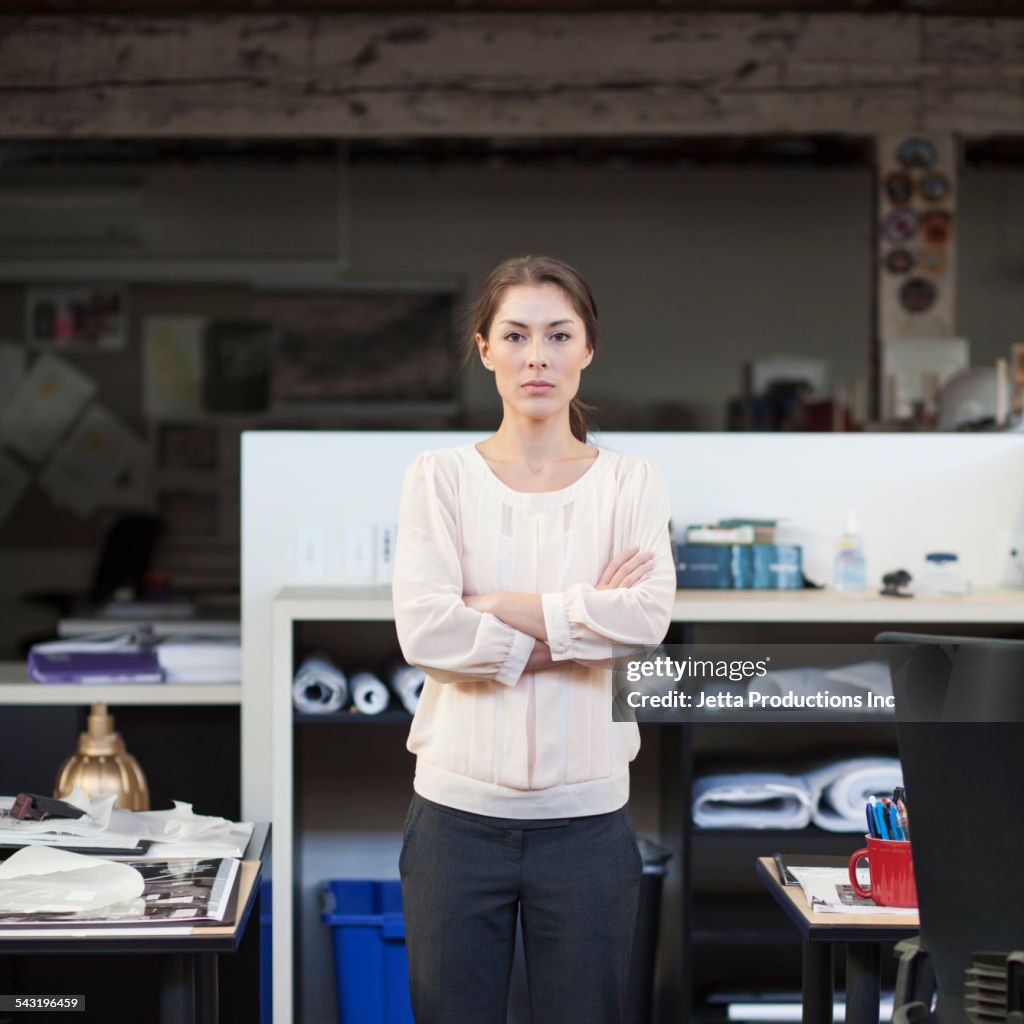 Mixed race businesswoman standing in office