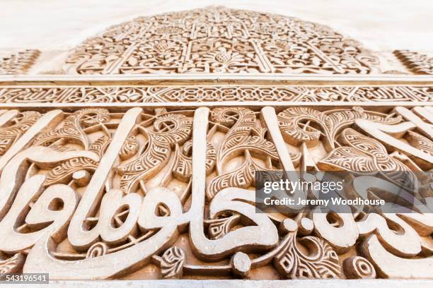 low angle view of arabic script relief carving - arabic script fotografías e imágenes de stock