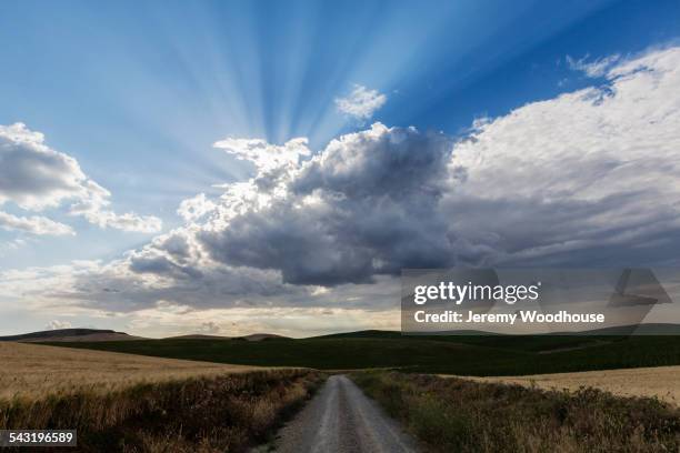 sunbeams streaming through clouds over remote landscape - cordoba spanien stock-fotos und bilder