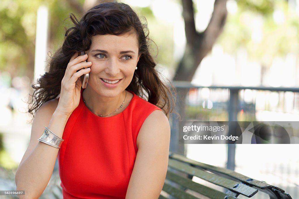 Caucasian businesswoman talking on cell phone in urban park