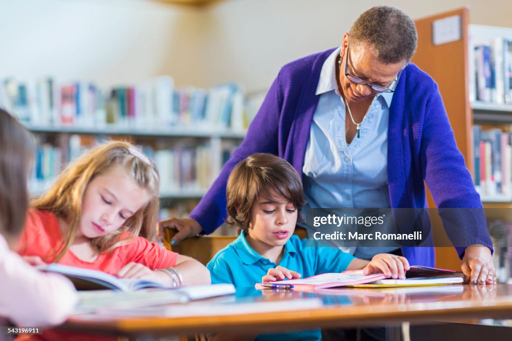 Teacher helping student in library