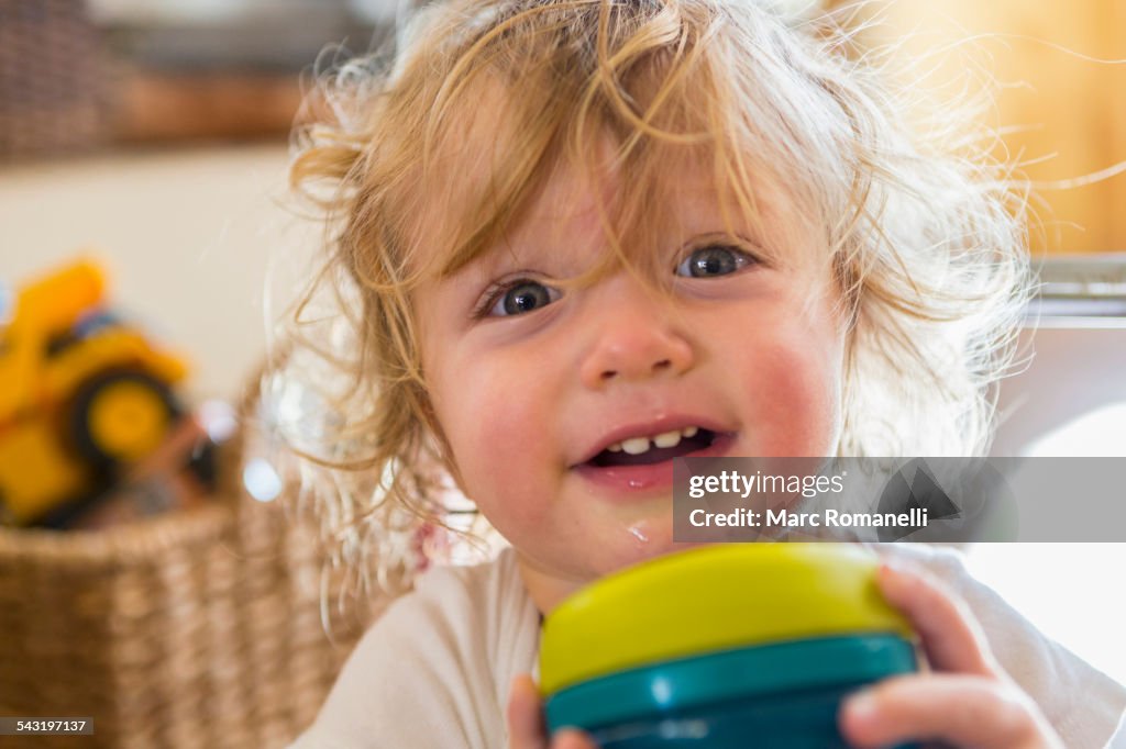 Caucasian baby holding cup
