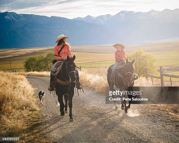 caucasian mother and son riding horses on ranch - american ranch landscape stock-fotos und bilder