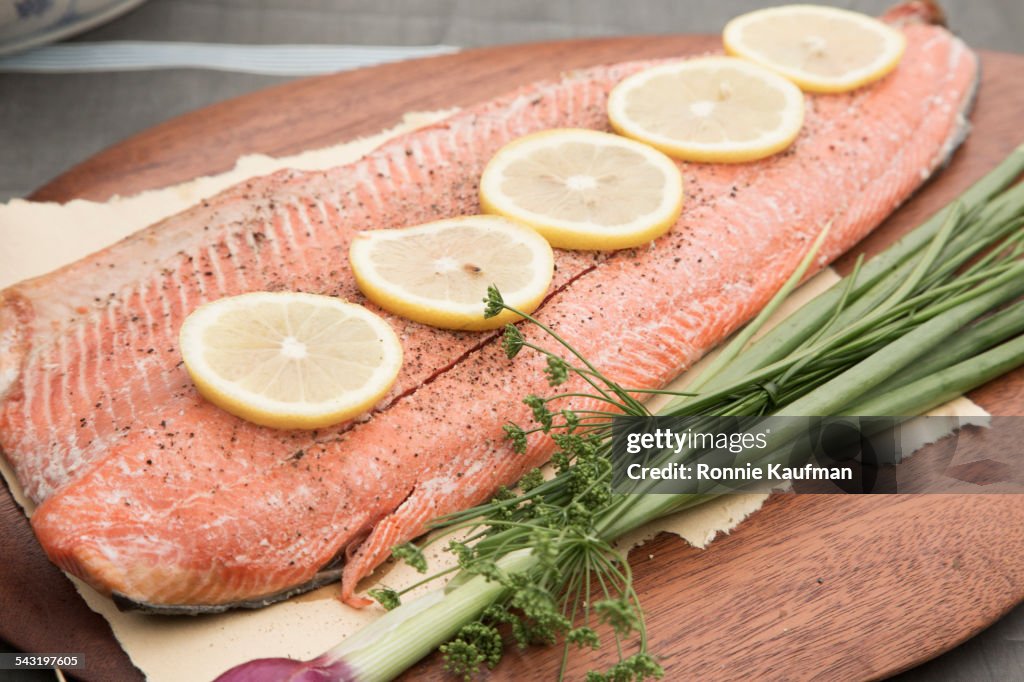 Close up of lemon slices and herbs on salmon