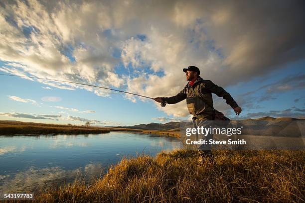 fisherman casting in river - fisherman stock photos et images de collection