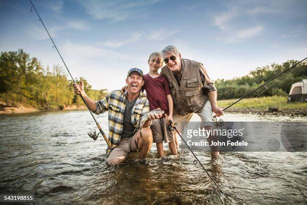 three generations of caucasian men fishing in river - boy river looking at camera stock pictures, royalty-free photos & images
