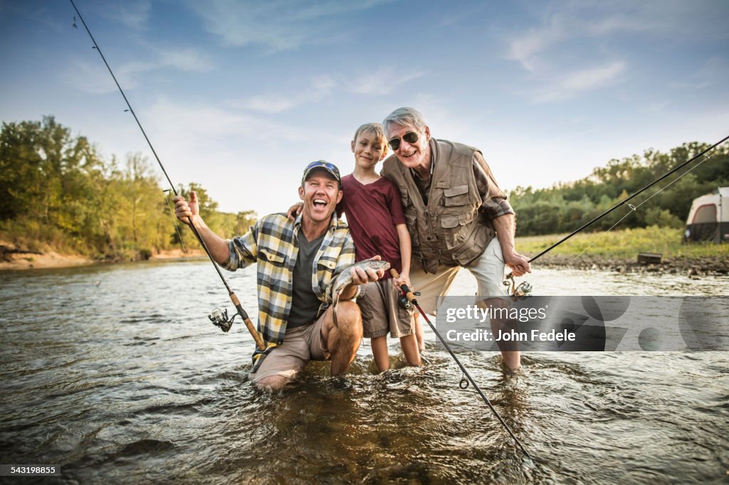 Three generations of Caucasian men fishing in river