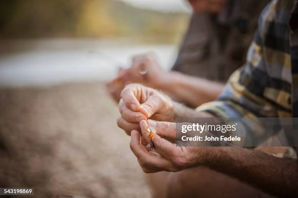 caucasian father and son tying fishing lures - fishing hook stock-fotos und bilder