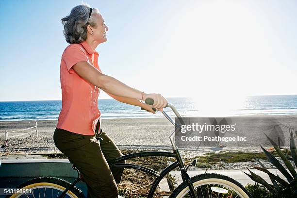 Caucasian woman riding bicycle near beach