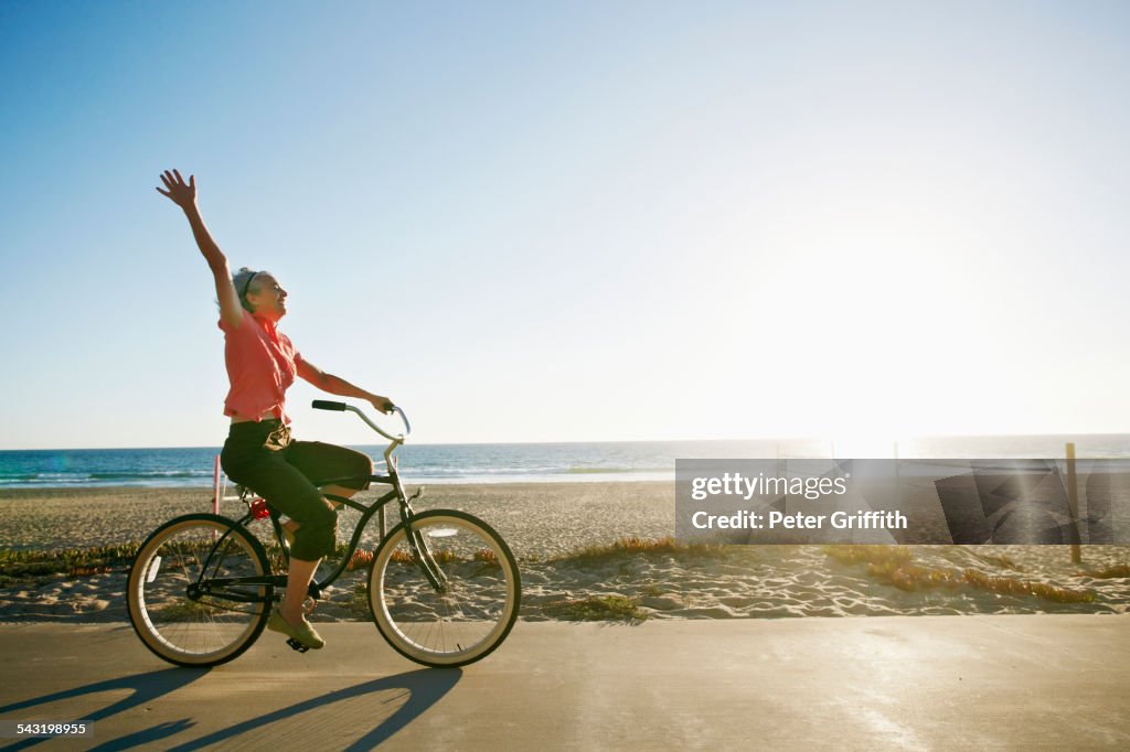 Caucasian woman riding bicycle near beach