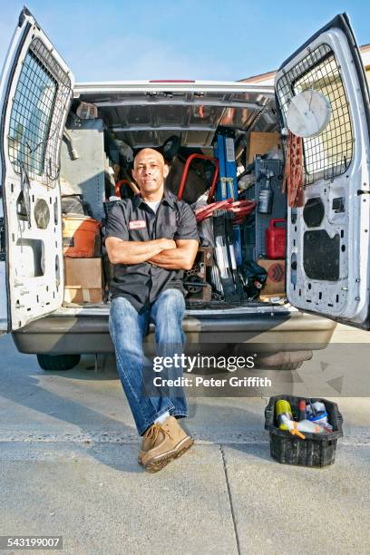 mixed race plumber sitting in van - rohrbruch stock-fotos und bilder