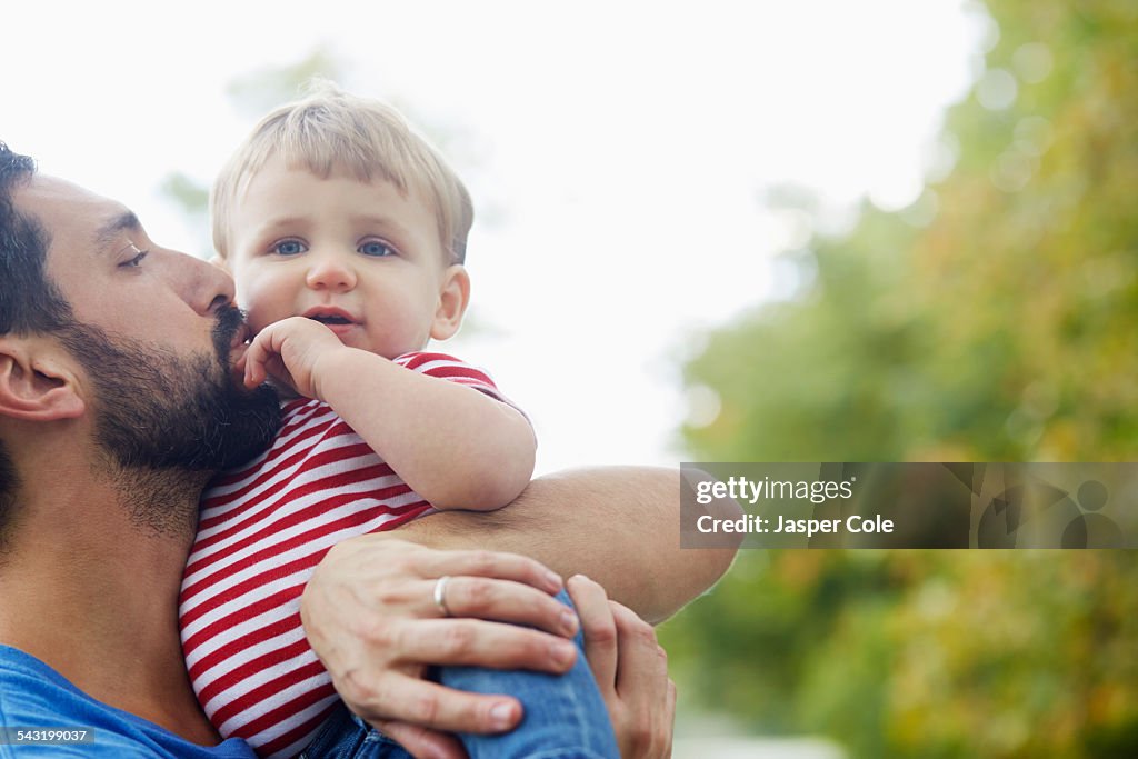 Caucasian father kissing baby son