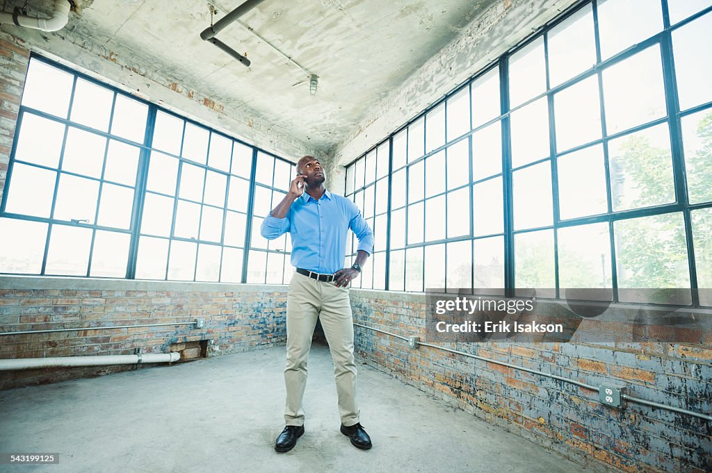 Black businessman talking on cell phone in warehouse