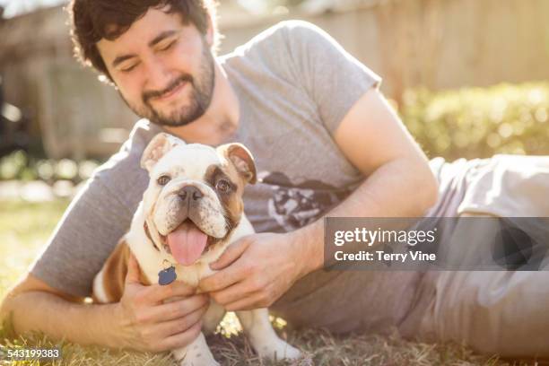 caucasian man petting dog on lawn - harris county stock pictures, royalty-free photos & images