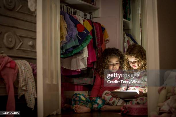 girls using digital tablet in closet - childrens closet stock pictures, royalty-free photos & images