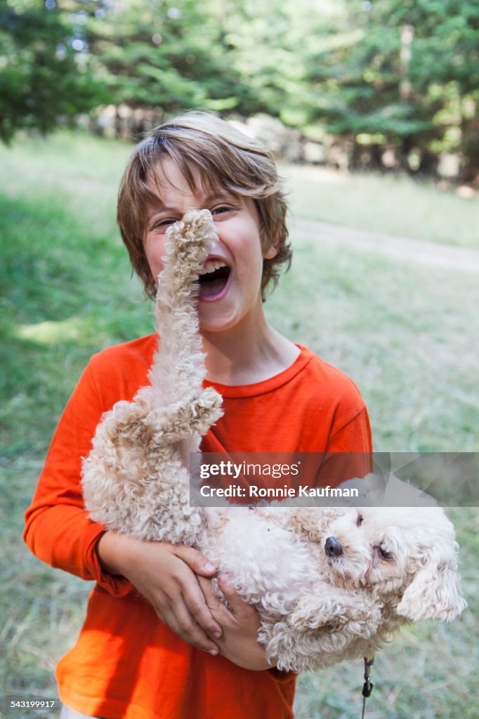 Caucasian boy playing with puppy outdoors