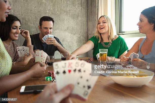 group of friends playing cards around table - poker card game stock pictures, royalty-free photos & images