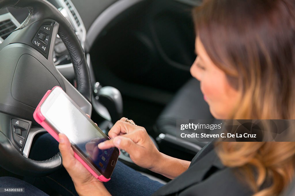 Business woman using smartphone in car