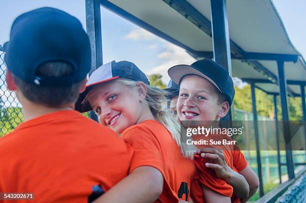 young baseball players with arms around each other, rear view - girl baseball cap stock pictures, royalty-free photos & images