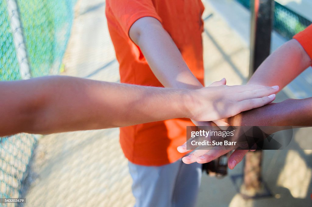 Young baseball players touching hands