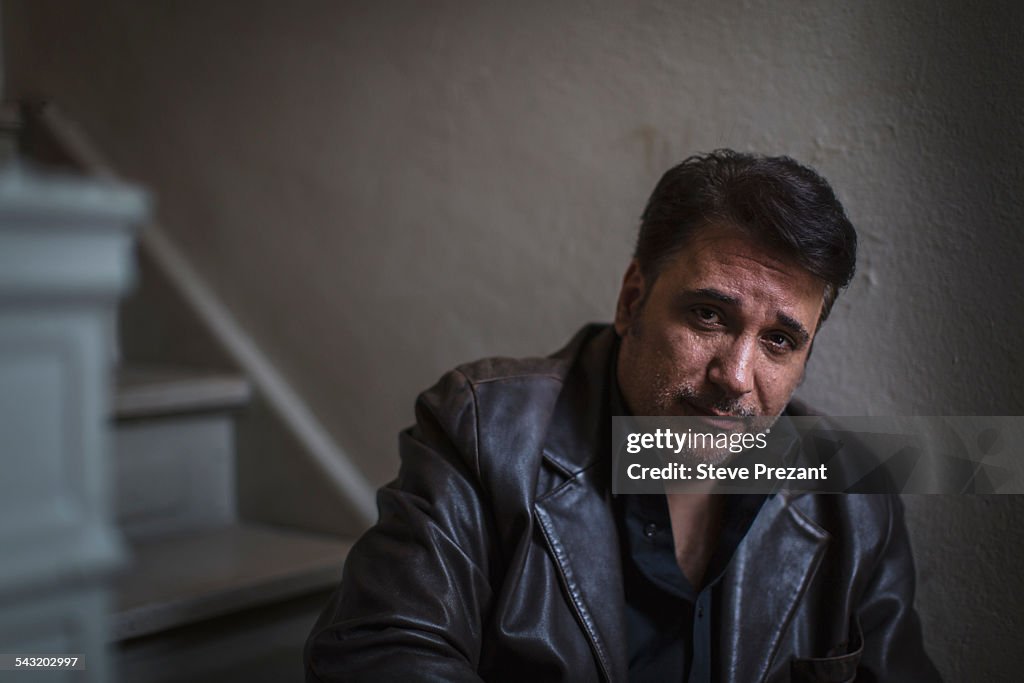 Portrait of mature man sitting alone on stairway