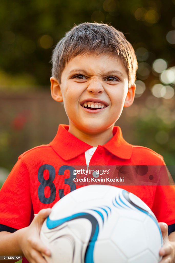 Boy with football, making faces
