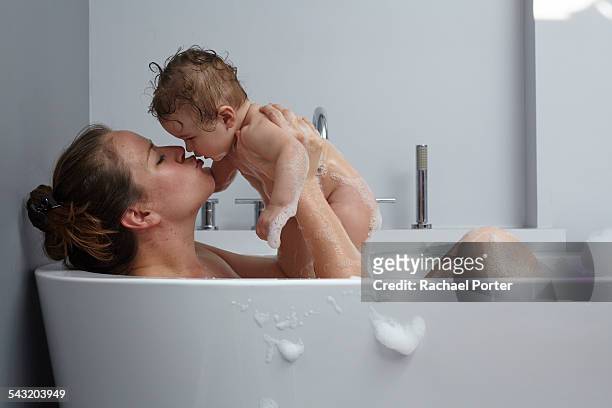 mother and baby girl in bathtub - taking a bath stock pictures, royalty-free photos & images