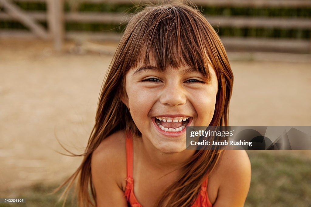 Portrait of laughing girl in farmyard