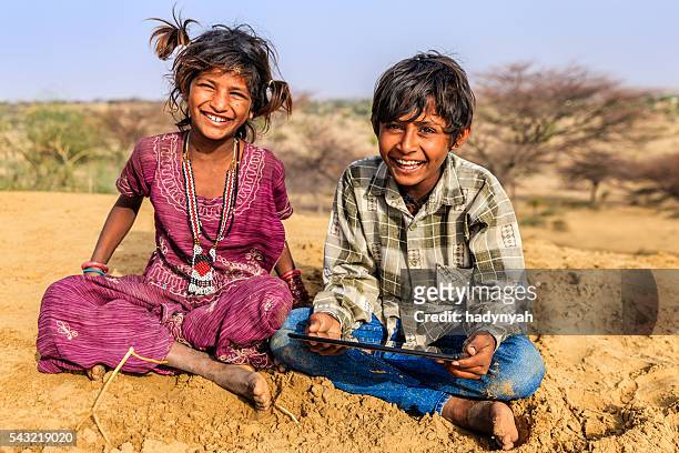 happy indian children using digital tablet, desert village, india - local gypsy stock pictures, royalty-free photos & images