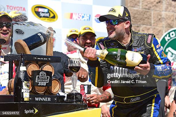 Tony Stewart, driver of the Code 3 Assoc/Mobil 1 Chevrolet, celebrates with champagne in victory lane after winning the NASCAR Sprint Cup Series...