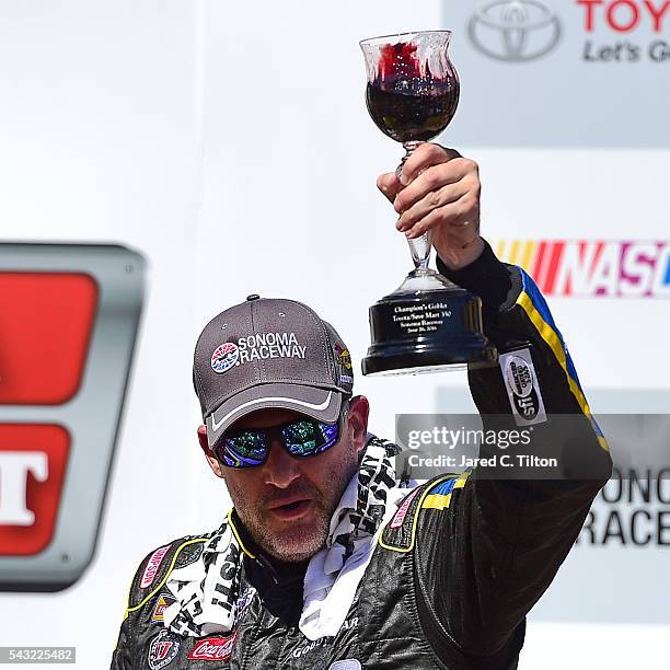 Tony Stewart, driver of the Code 3 Assoc/Mobil 1 Chevrolet, celebrates in victory lane with wine after winning the NASCAR Sprint Cup Series...