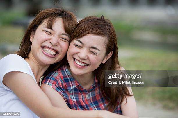 friends in the park. - young asian friends hugging stock-fotos und bilder