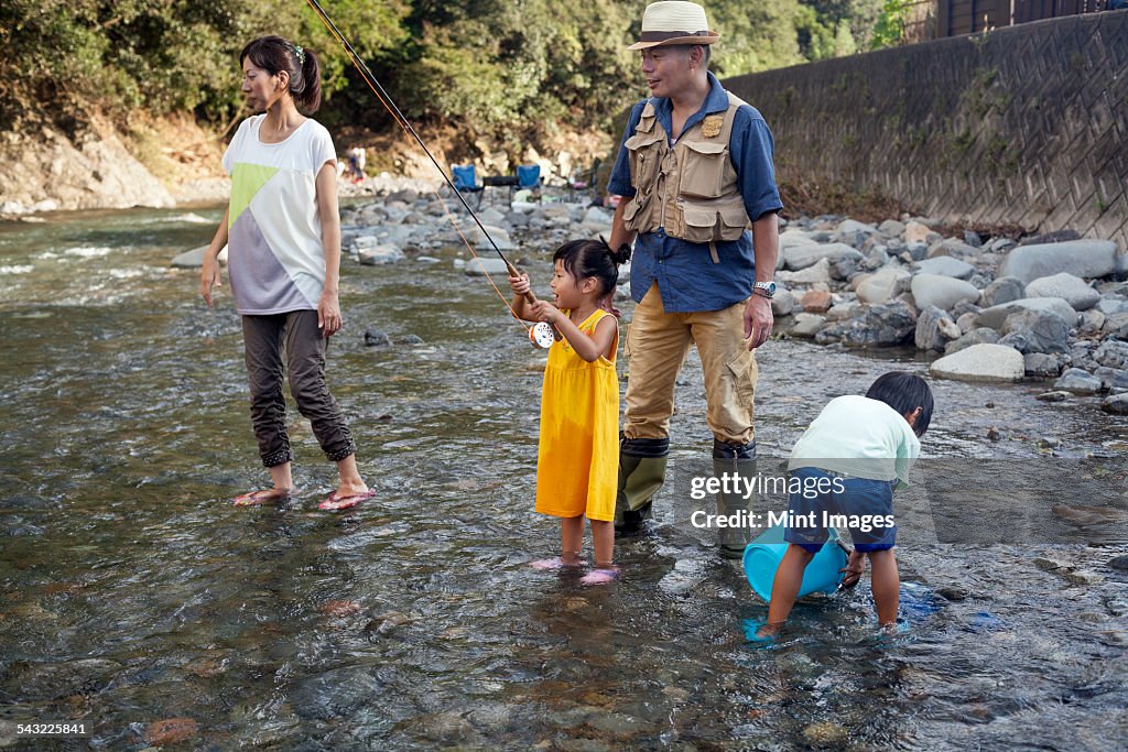 Family fishing in a stream.