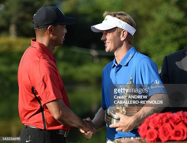 Billy Hurley III shakes hands with Tiger Woods after the final round of the Quicken Loans National at Congressional Country Club in Bethesda,...
