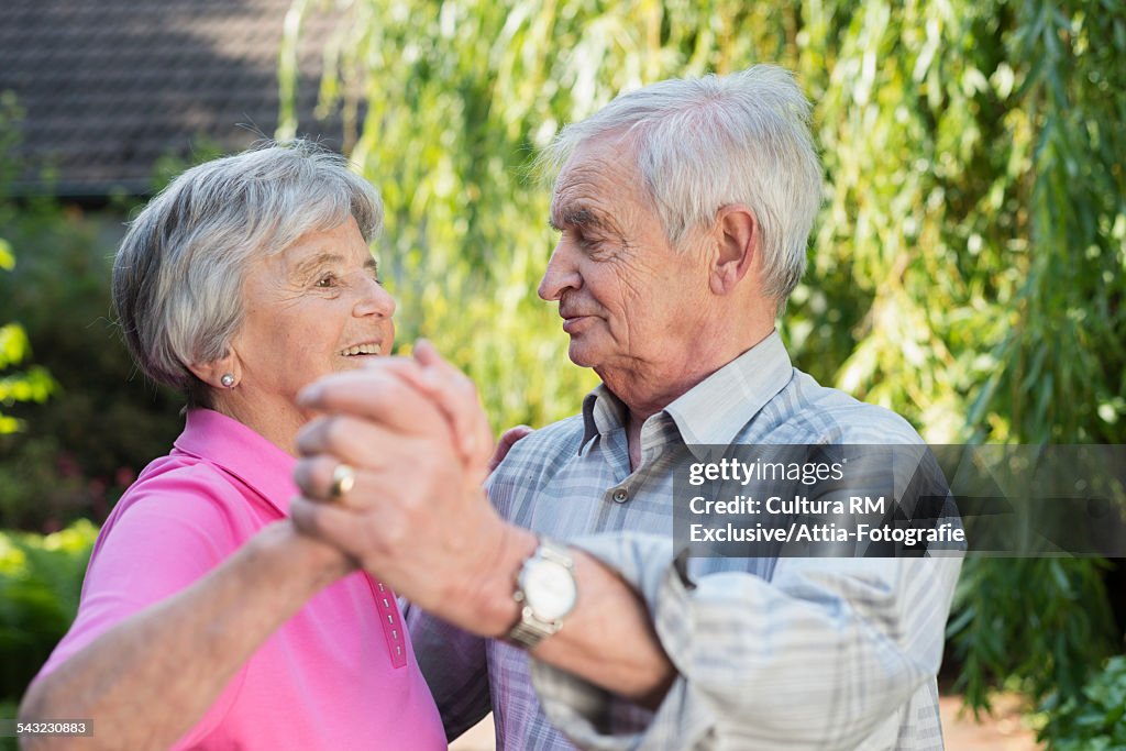 Senior couple waltzing in garden