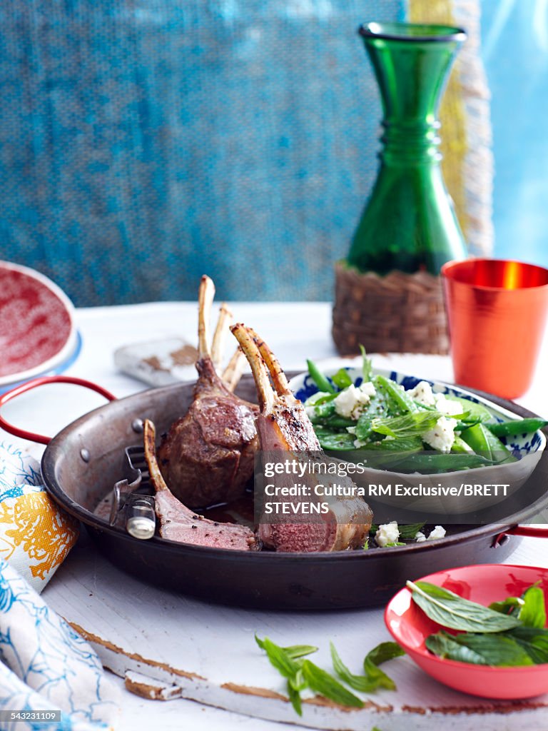 Still life of spring lamb chops with mint peas and feta cheese
