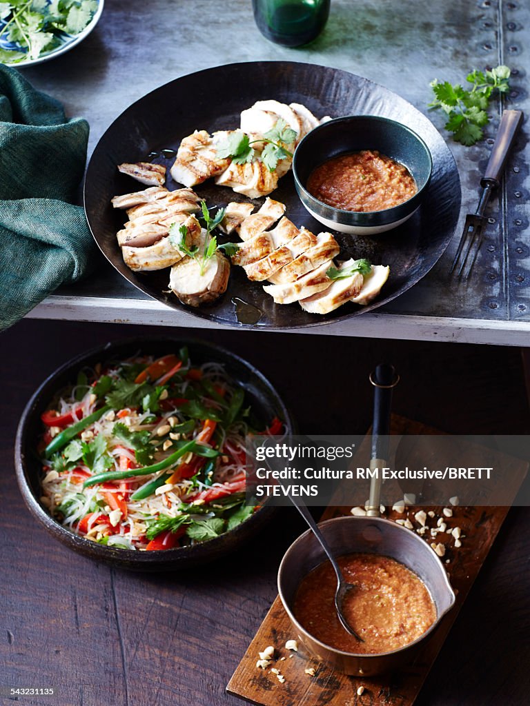 Still life of chicken with peanut sauce and salad
