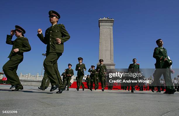 Chinese soldiers leave the Monument to the People's Heroes after paying respects during a memorial ceremony at Tiananmen Square to mark the defeat of...