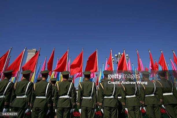 Chinese soldiers stand next to the Monument to the People's Heroes during a memorial ceremony at Tiananmen Square to mark the defeat of Japan 60...
