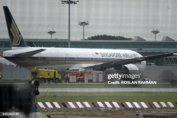 Singapore Airlines Boeing 777-300ER aircraft, its starboard wing charred from an engine fire while making an emergency landing, is towed across the...