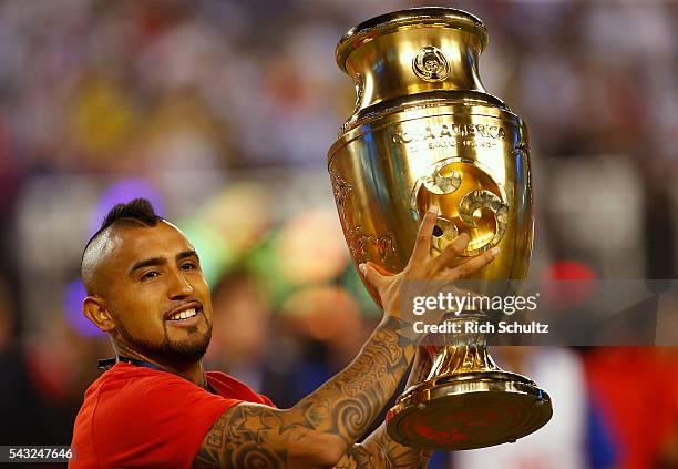 Arturo Vidal of Chile holds the trophy after winning the championship match between Argentina and Chile at MetLife Stadium as part of Copa America...