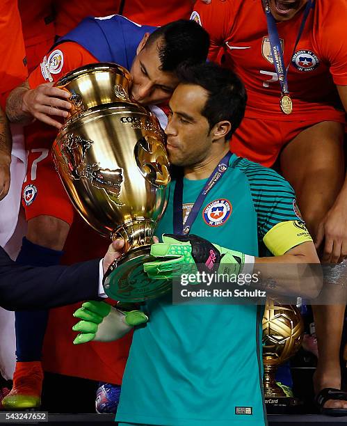 Claudio Bravo and Gary Medel of Chile kiss the trophy after winnig the championship match between Argentina and Chile at MetLife Stadium as part of...