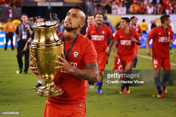Arturo Vidal of Chile celebrates with the trophy after winning the championship match between Argentina and Chile at MetLife Stadium as part of Copa...