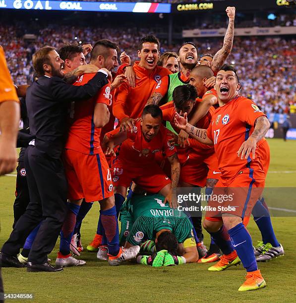 Claudio Bravo of Chile is mobbed by his teammates after defeating Argentina to win the Copa America Centenario Championship match at MetLife Stadium...